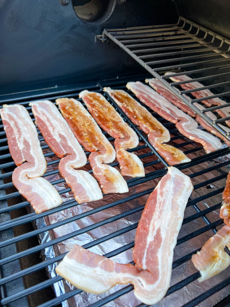 uncooked bacon on a Traeger smoker