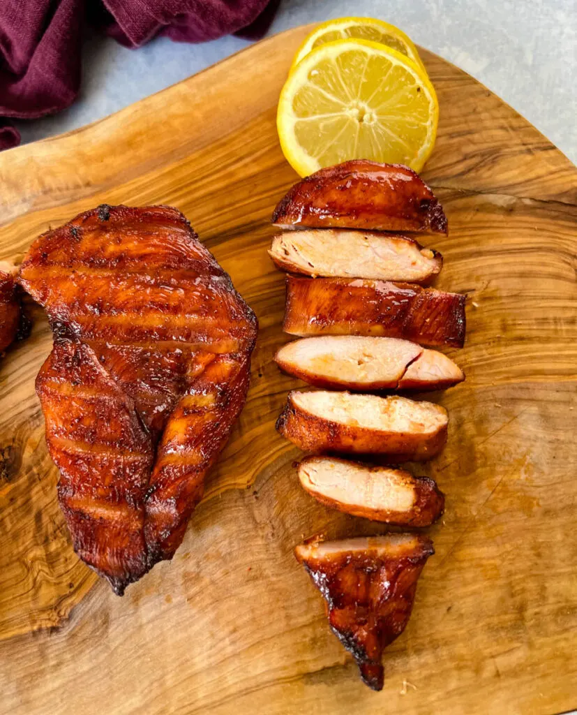 Traeger smoked chicken breasts on a plate with lemons