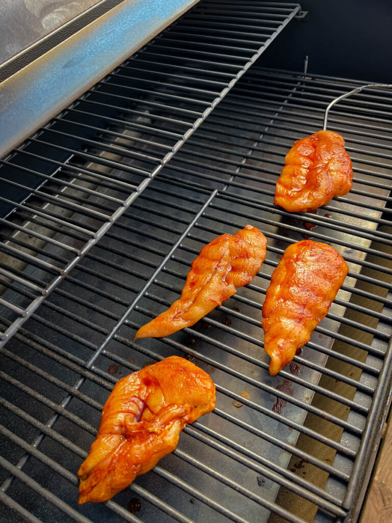 raw chicken breasts on a Traeger smoker grill