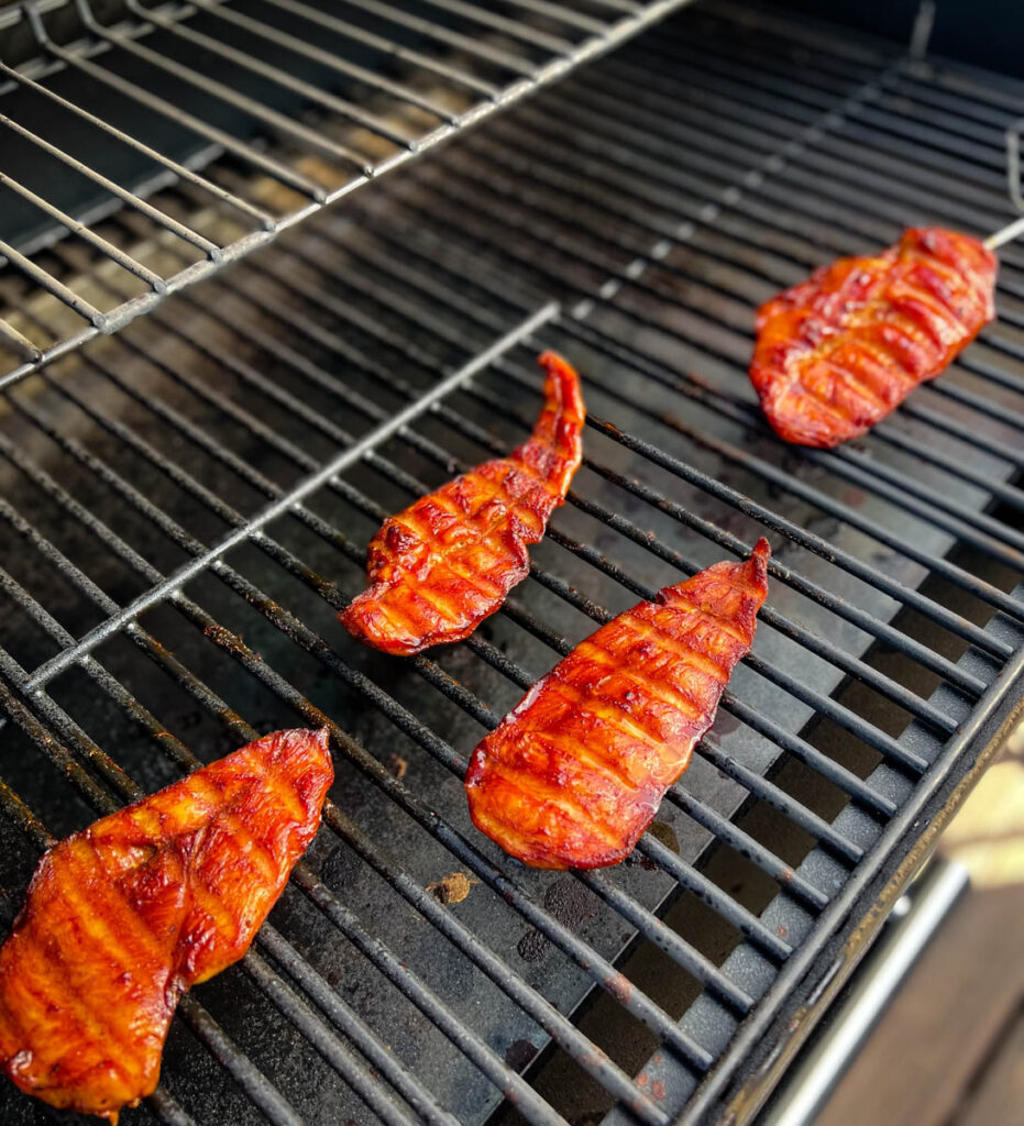 chicken breasts on a Traeger smoker grill with a probe