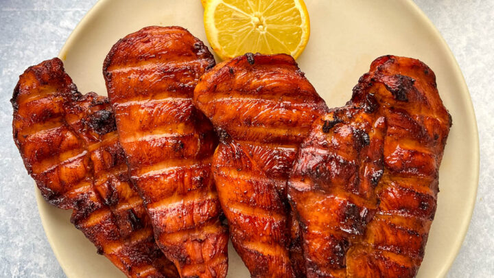 Traeger smoked chicken breasts on a plate with lemons