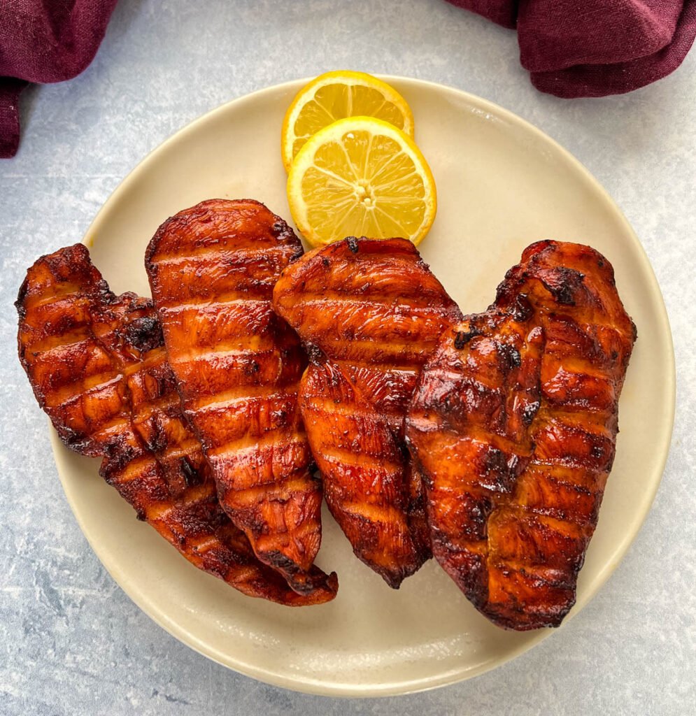 Traeger smoked chicken breasts on a plate with lemons