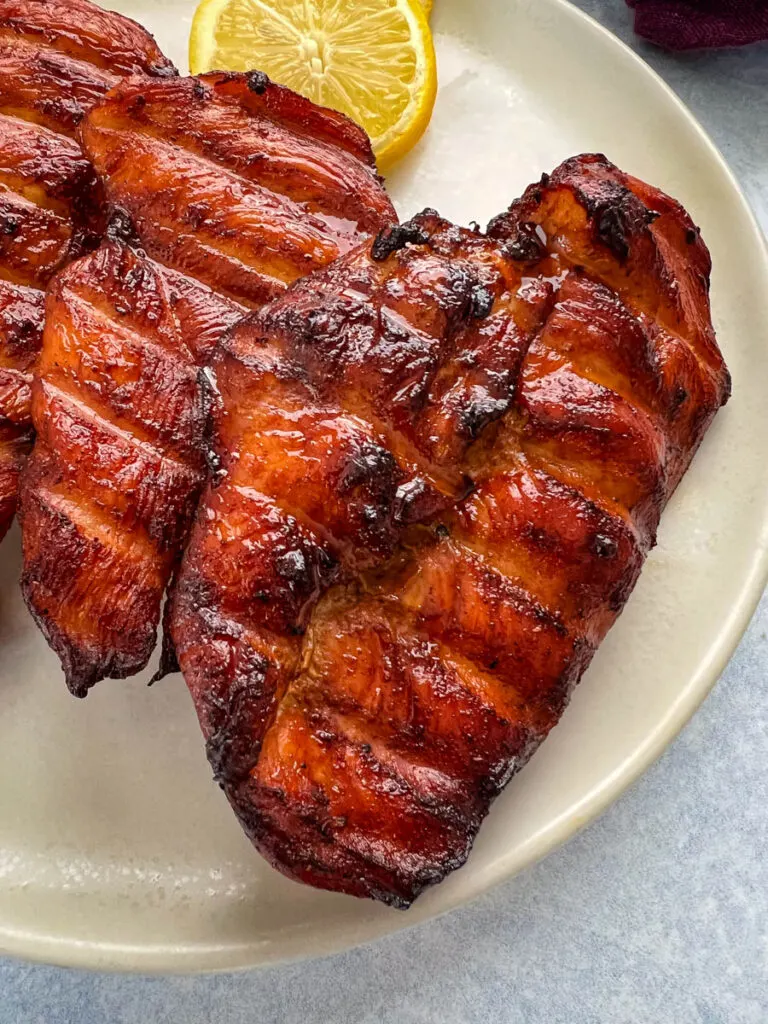 Traeger smoked chicken breasts on a plate with lemons