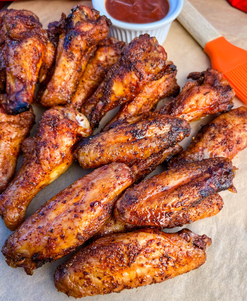 Traeger smoked chicken wings on a plate with BBQ sauce