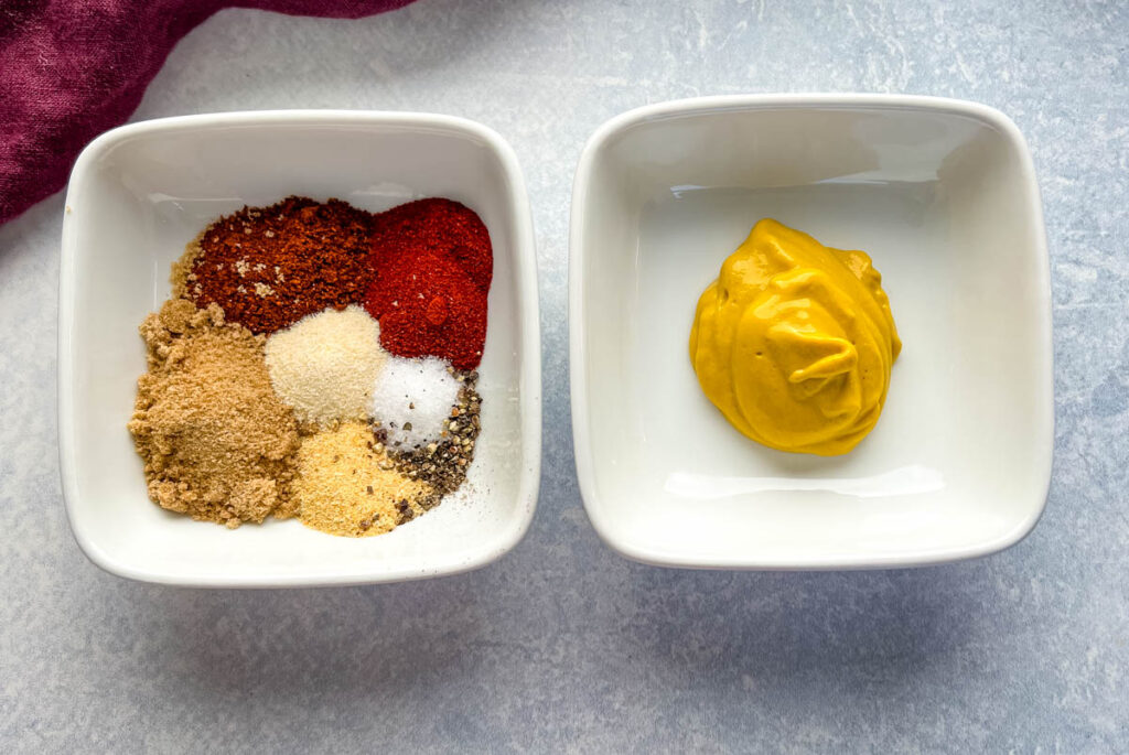 dry pork rib rub and mustard in separate white bowls