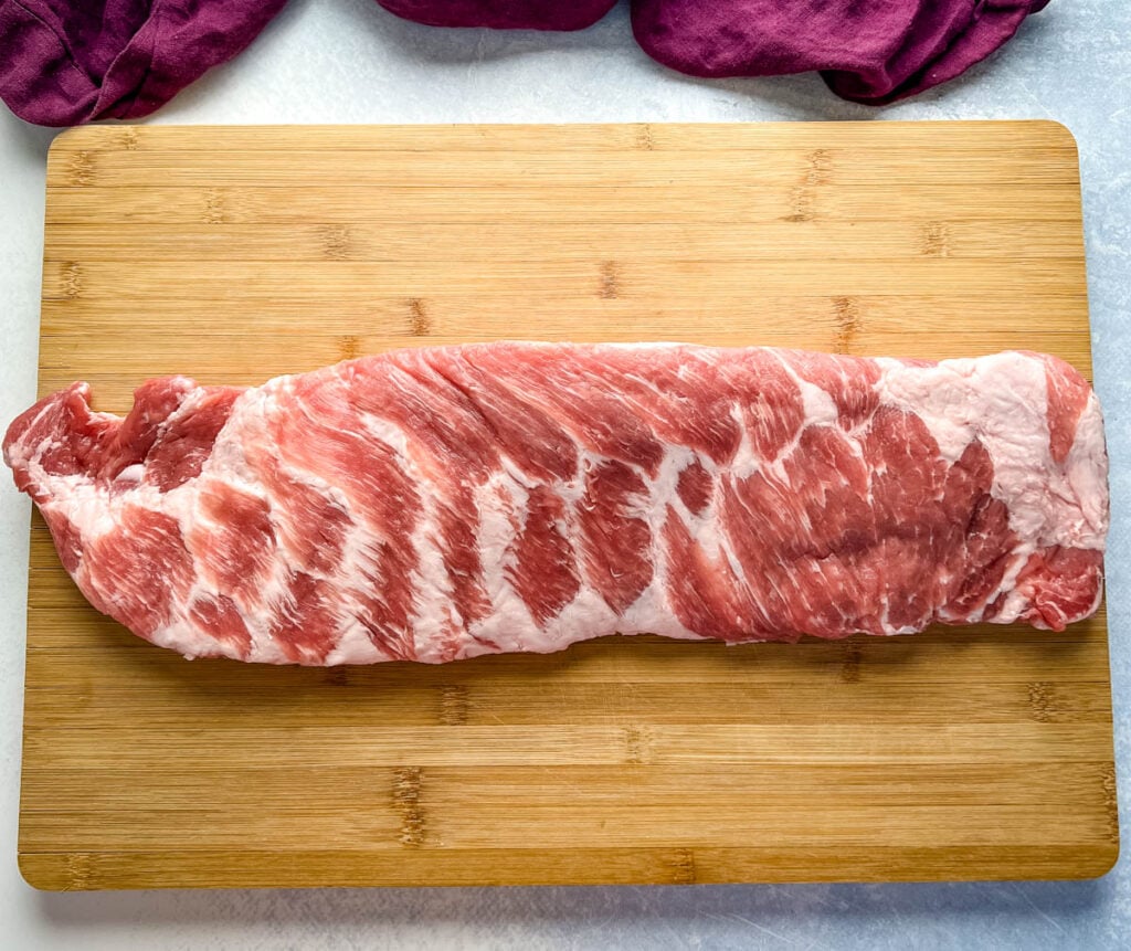 raw spare ribs on a cutting board