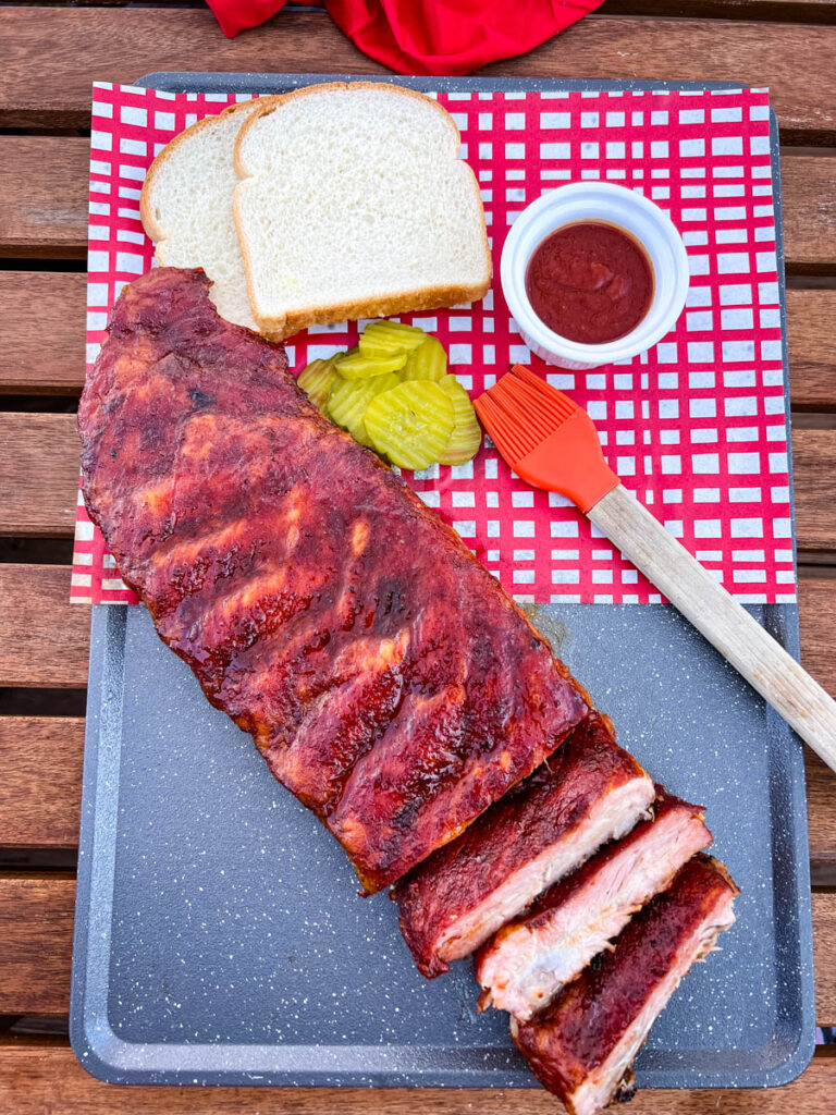 Traeger smoked ribs on a plate with pickles and white bread