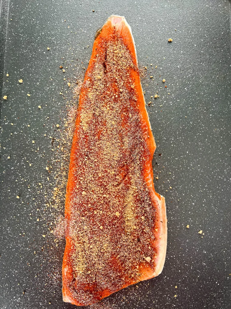 raw seasoned wild caught salmon on a sheet pan