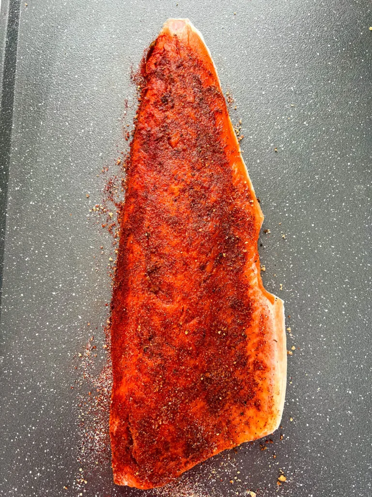 raw seasoned wild caught salmon on a sheet pan