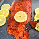 Traeger smoked salmon on a plate with fresh lemons