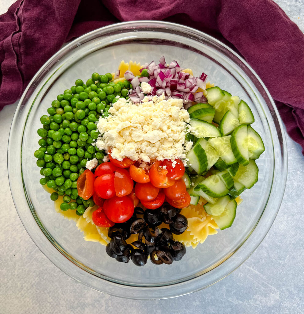 bow tie farfalle pasta salad with vegetables with Italian dressing in a glass bowl bowl