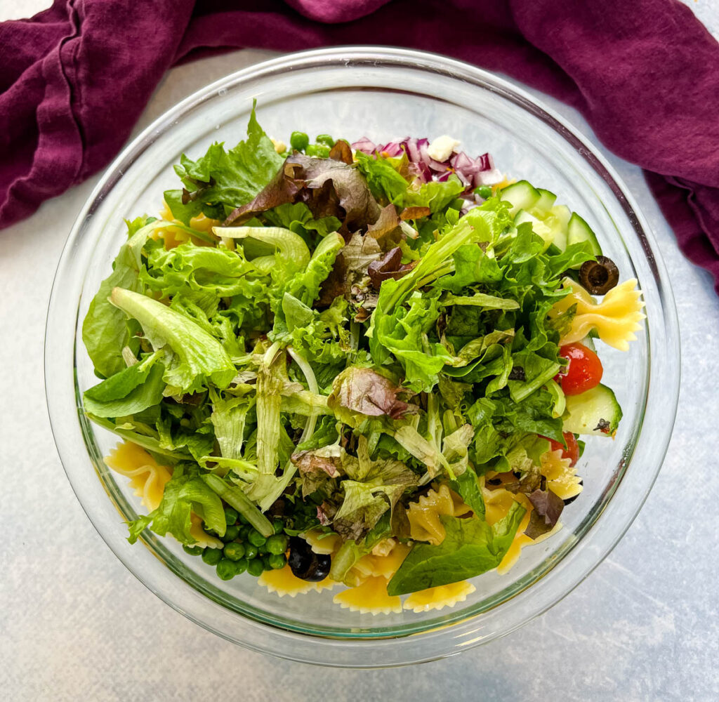 bow tie farfalle pasta salad with vegetables with Italian dressing in a glass bowl bowl