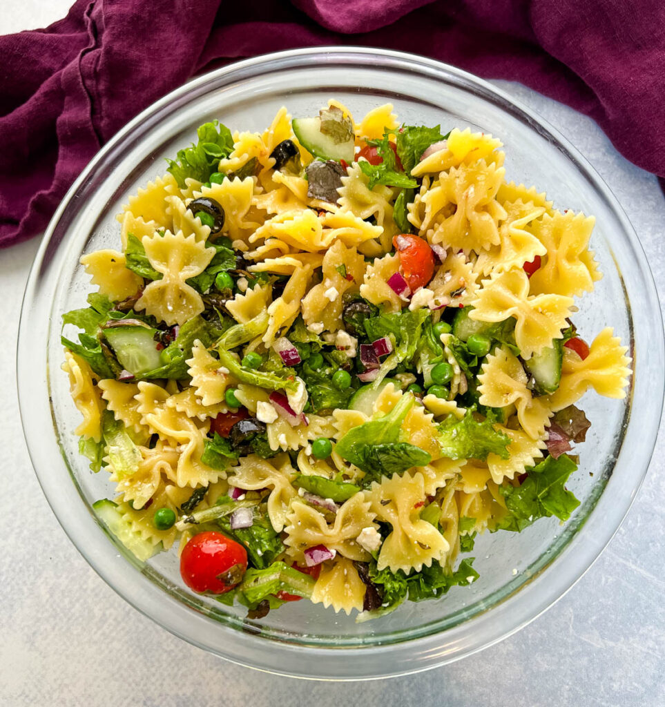 bow tie farfalle pasta salad with vegetables with Italian dressing in a glass bowl bowl