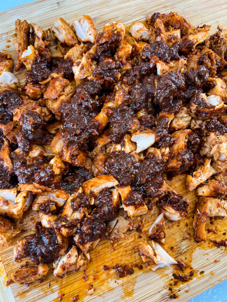 pollo asado on a cutting board with sauce