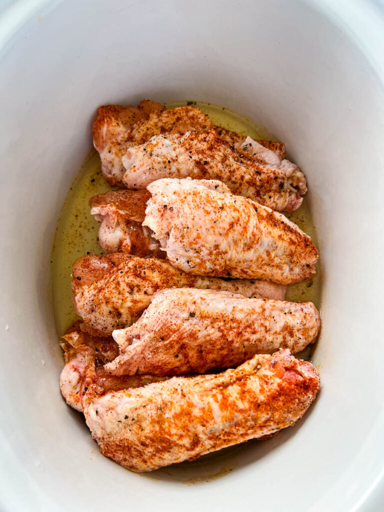 raw seasoned turkey wings in a Crockpot slow cooker