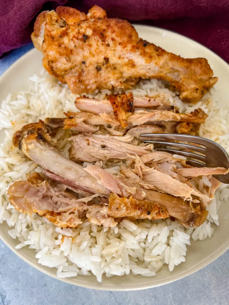 fall off the bone slow cooker turkey wings on a plate with rice