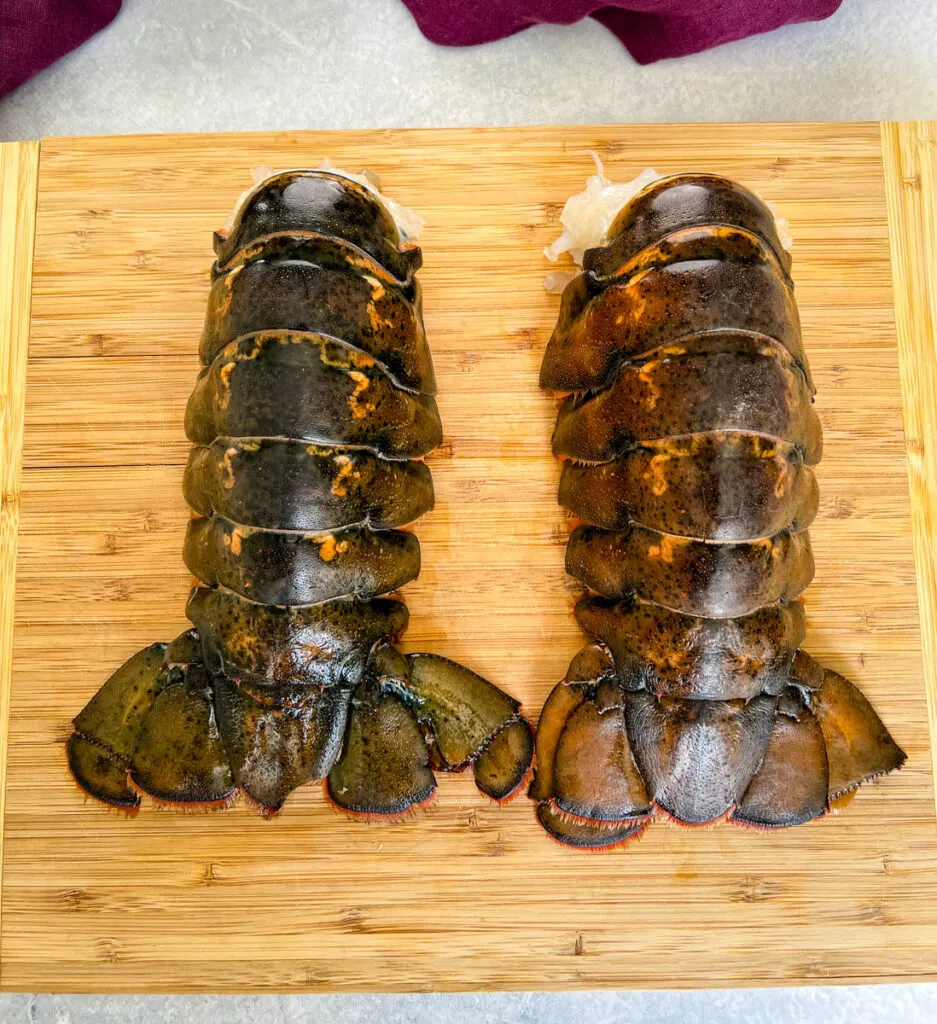 raw lobster tails on a cutting board