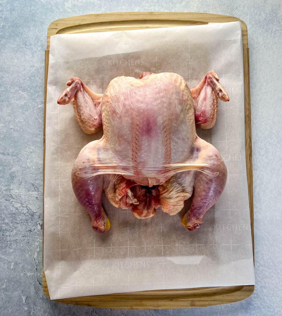 raw whole chicken on a cutting board