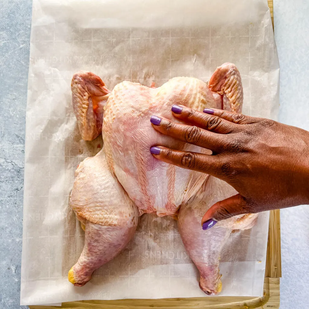 raw whole chicken on a cutting board