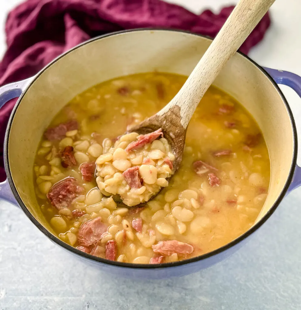 a spoonful of Southern butter lima beans in a Dutch oven