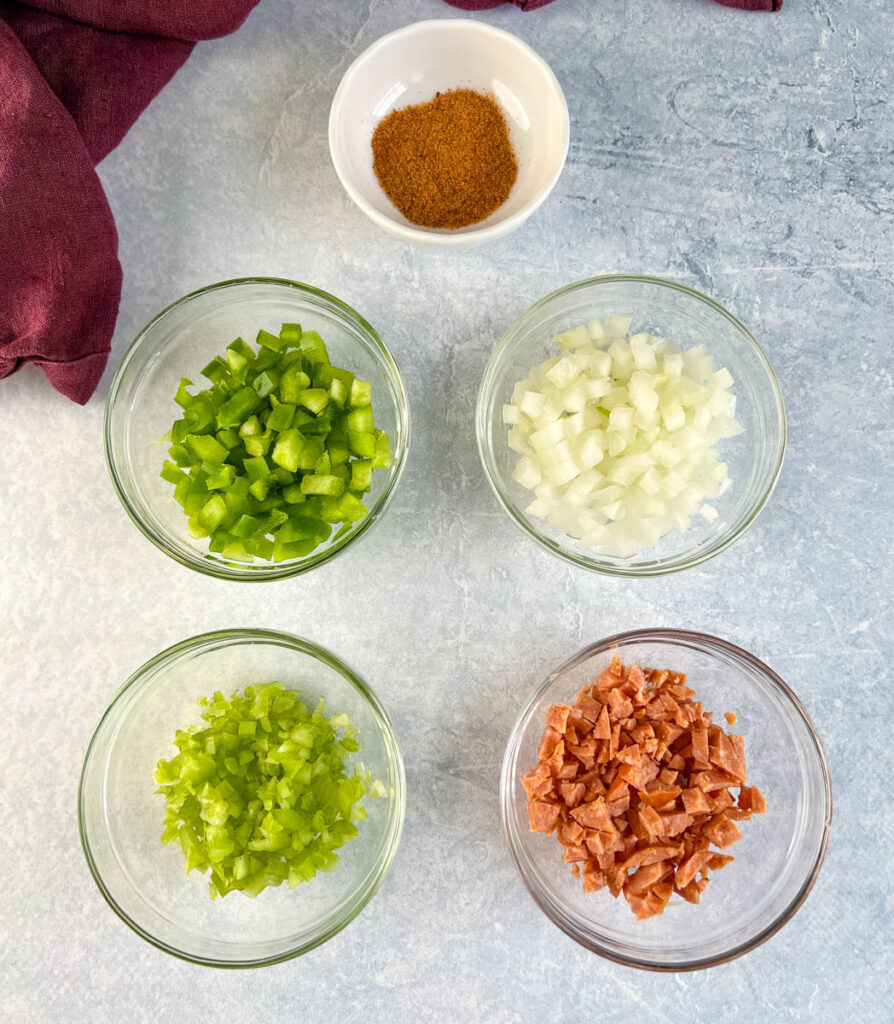 chopped vegetables, and chicken rub spices in separate glass bowls