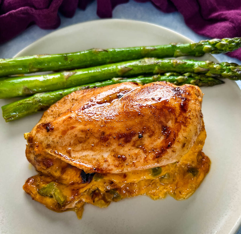oven baked stuffed chicken breast on a plate with asparagus