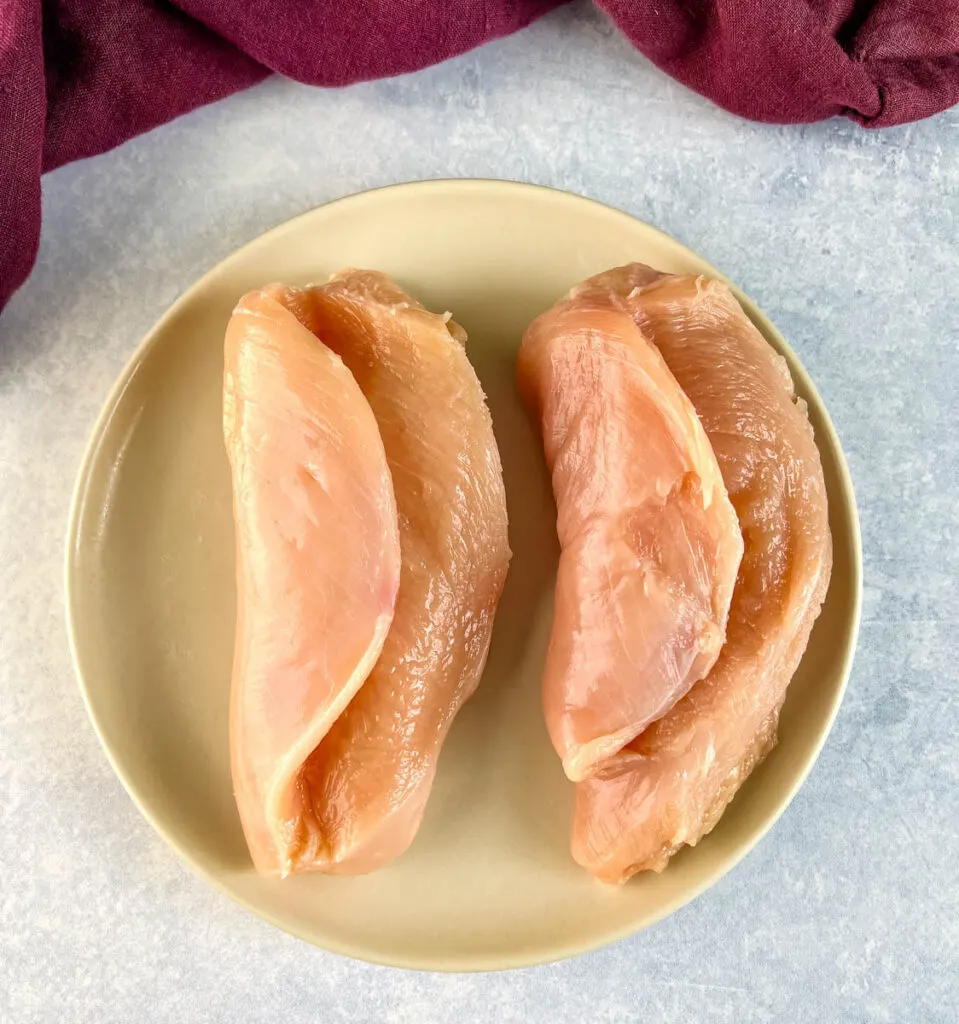 raw sliced chicken breasts on a plate
