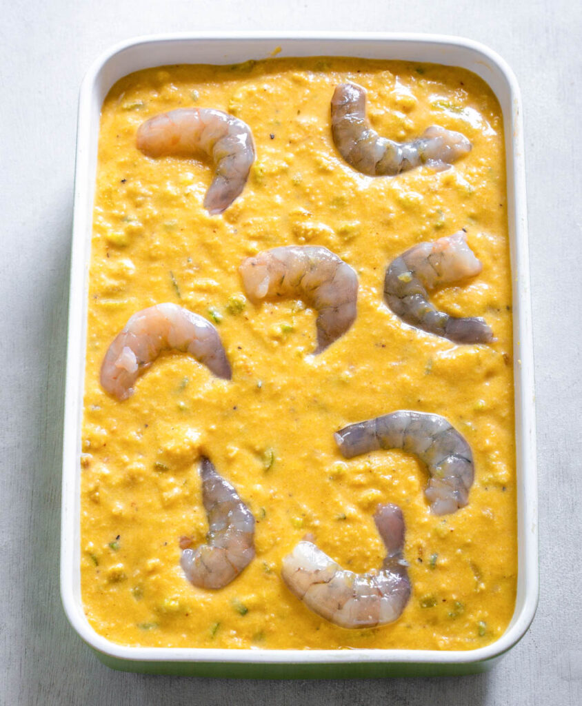 unbaked seafood cornbread dressing with shrimp in a baking dish