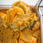 a large spoonful of seafood cornbread dressing with crab and shrimp