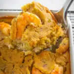 a large spoonful of seafood cornbread dressing with crab and shrimp