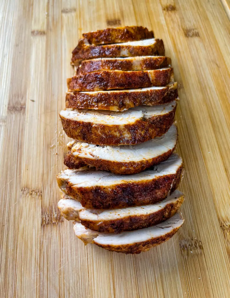 slow cooker Crockpot boneless turkey breast sliced on a bamboo cutting board