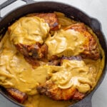 southern smothered pork chops in a cast iron skillet with gravy