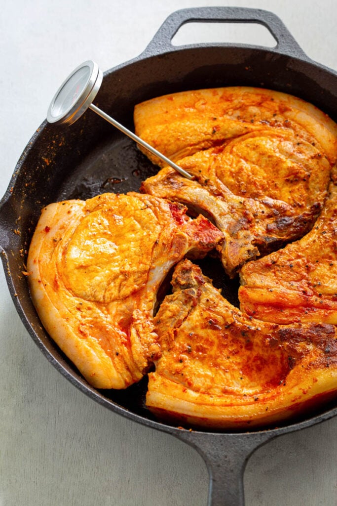 cooked pork chops in a cast iron skillet