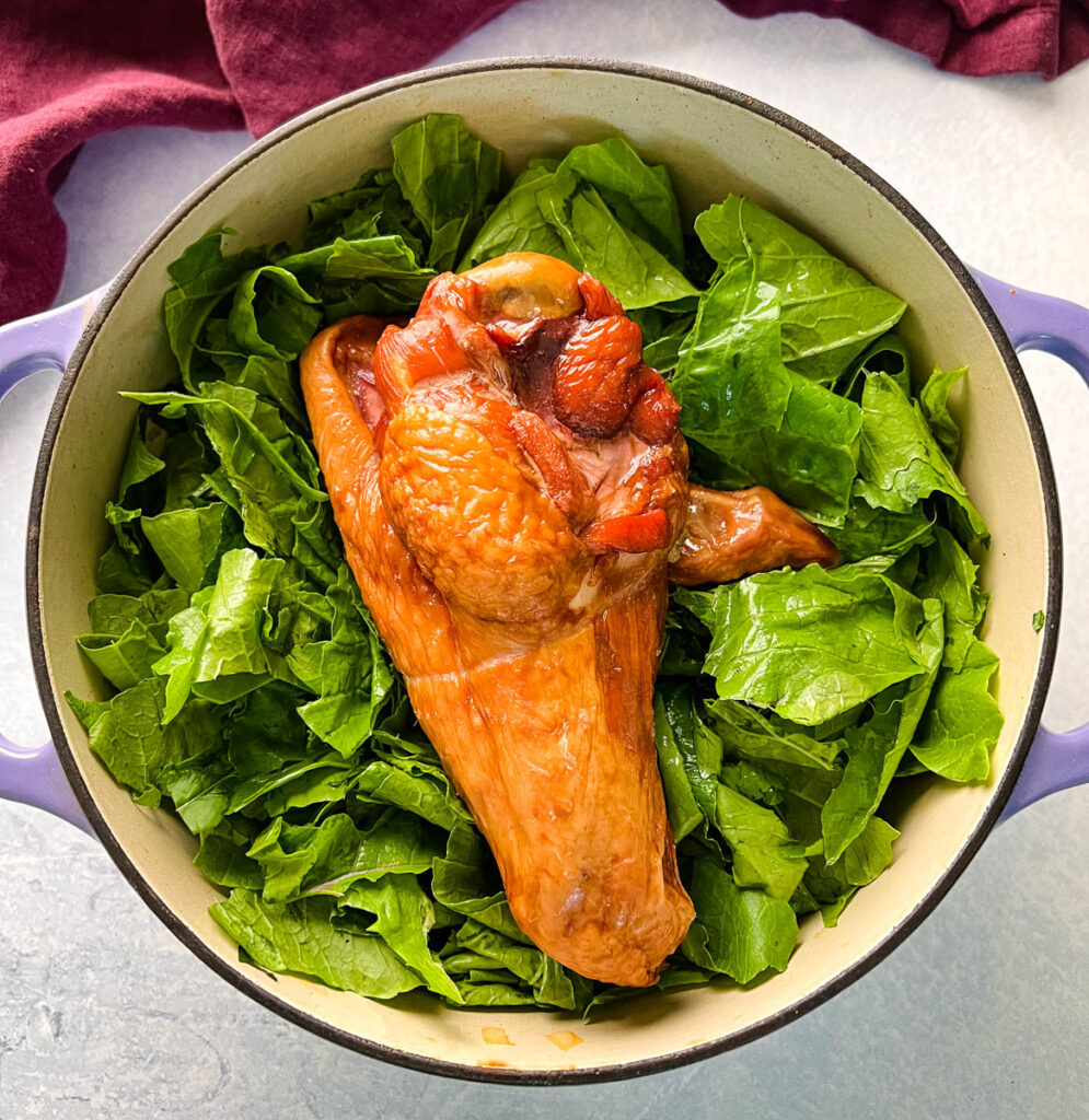 uncooked turnip greens and smoked turkey in a Dutch oven