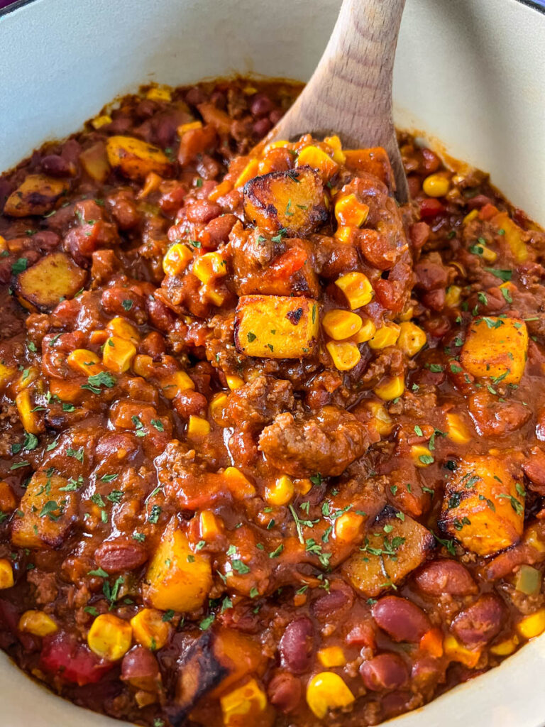 a large wooden spoonful of butternut squash chili