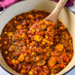 a large wooden spoonful of butternut squash chili