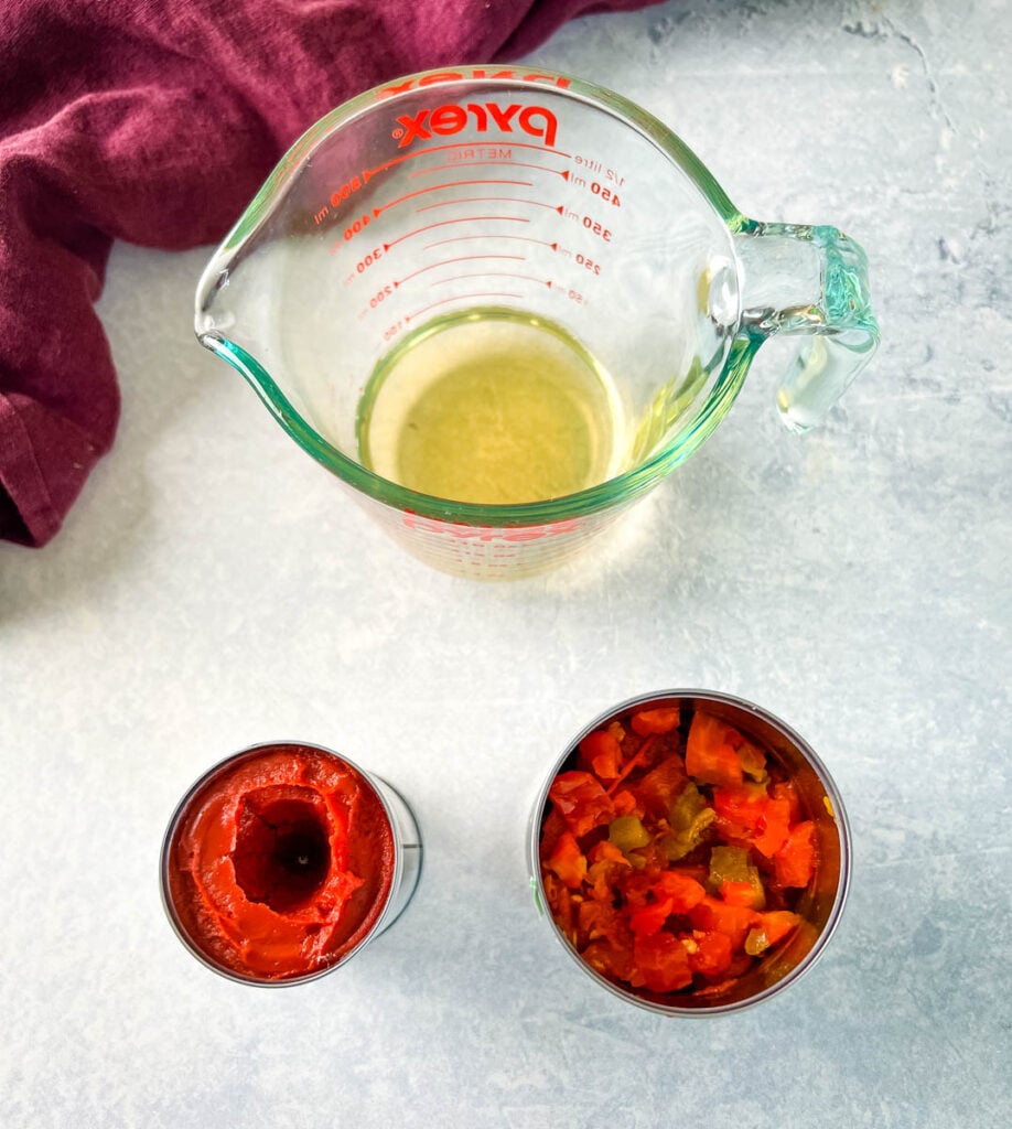 broth, tomato paste, and diced tomatoes on a flat surface