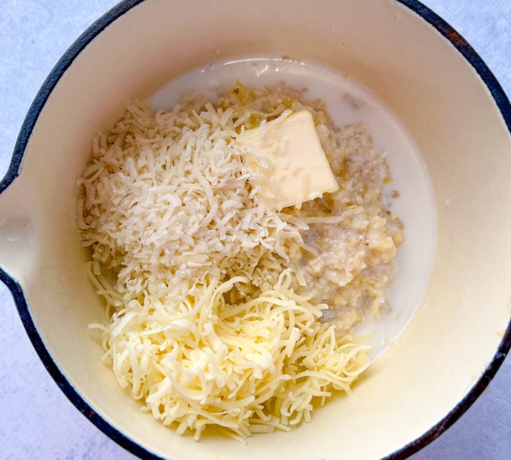 cooked grits in a pot with butter and cheese