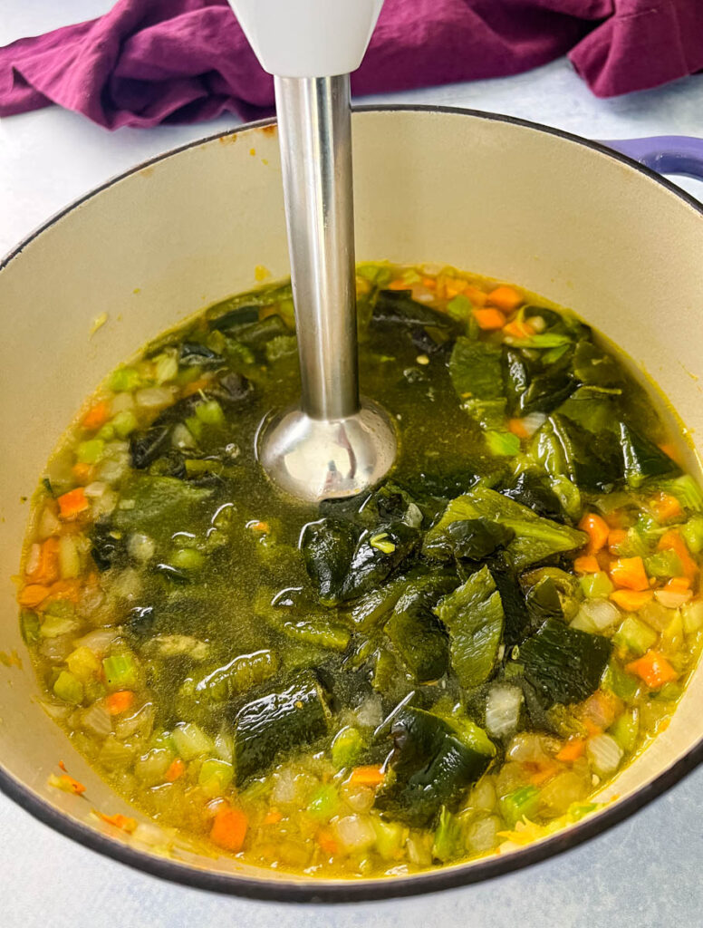 roasted poblano soup in a Dutch oven with an immersion blender