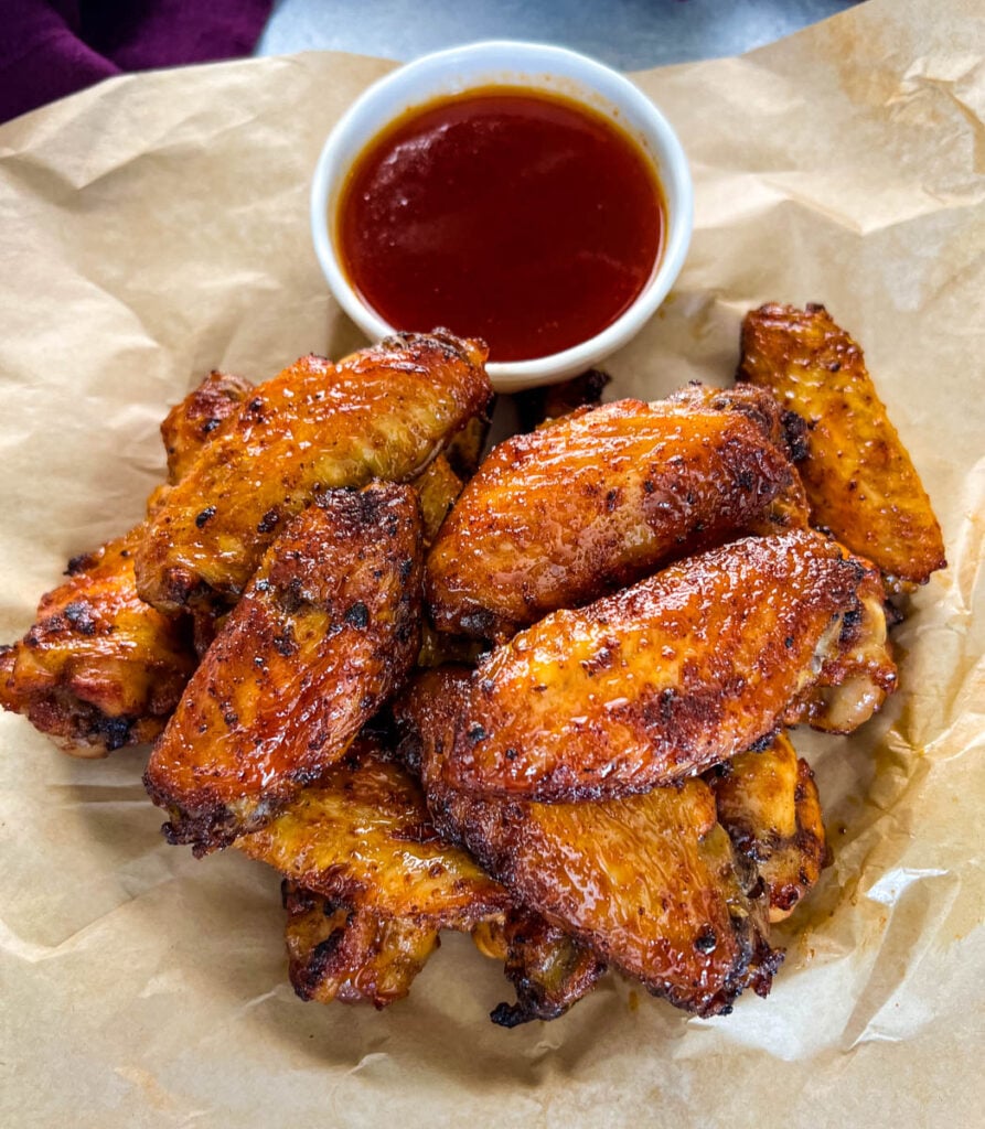honey hot wings on a plate with hot sauce