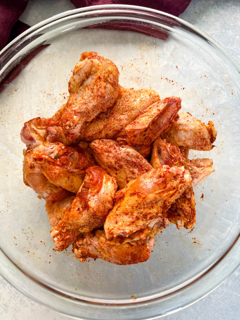 seasoned chicken wings in a glass bowl