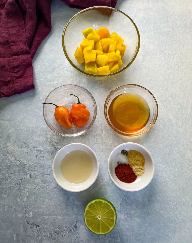 mangos, habaneros, honey, vinegar, spices, and lime in separate bowls