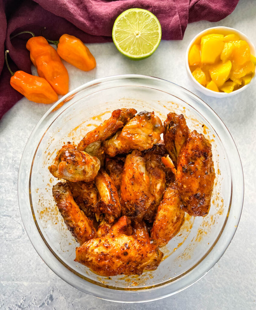 raw seasoned chicken wings in a glass bowl