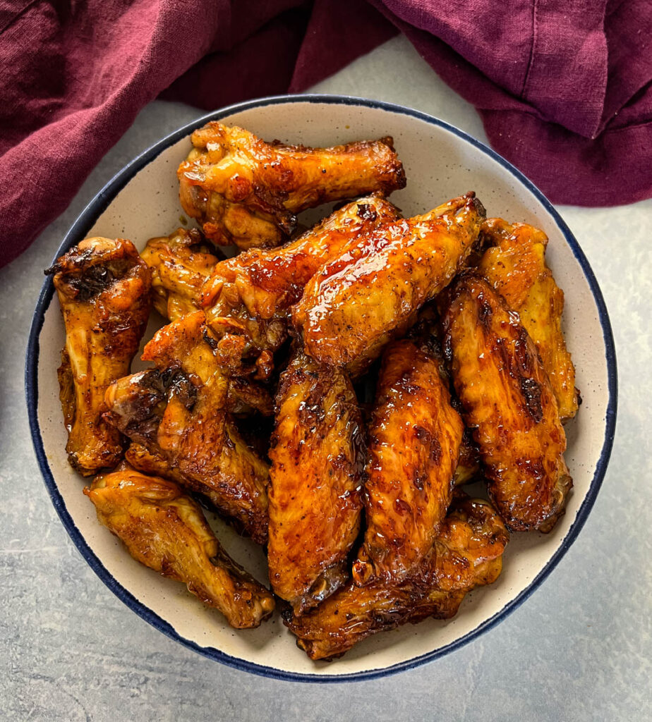 teriyaki chicken wings in a white and blue bowl