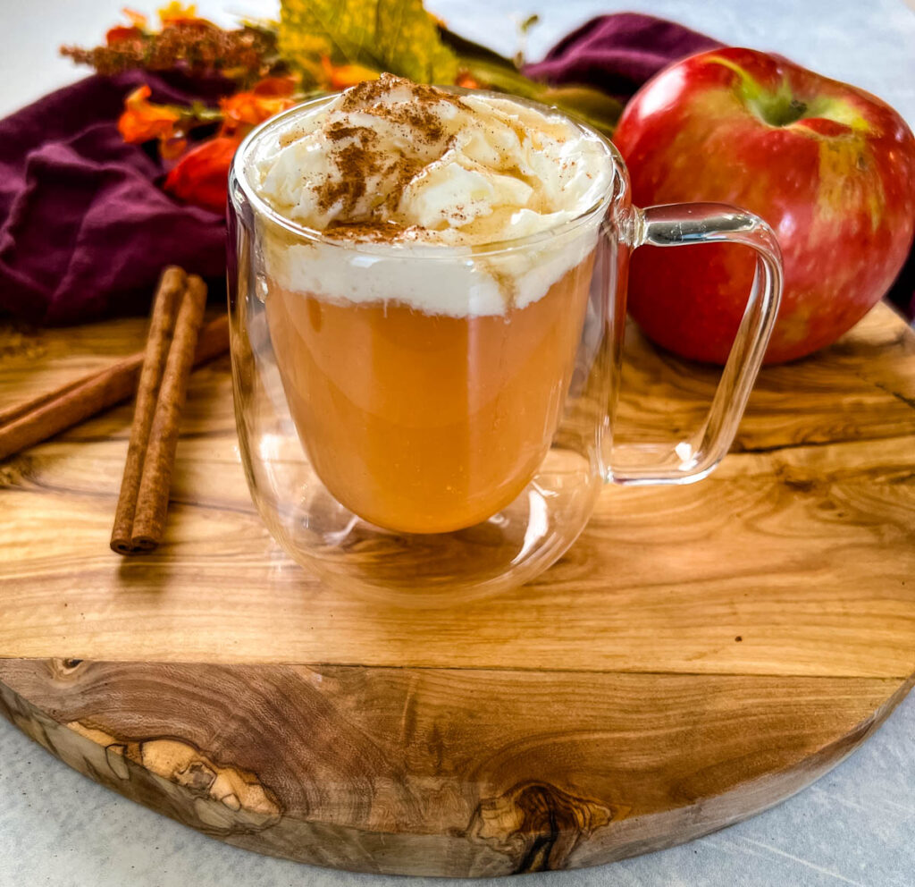 caramel apple spice cider Starbucks with whipped cream in a glass mug