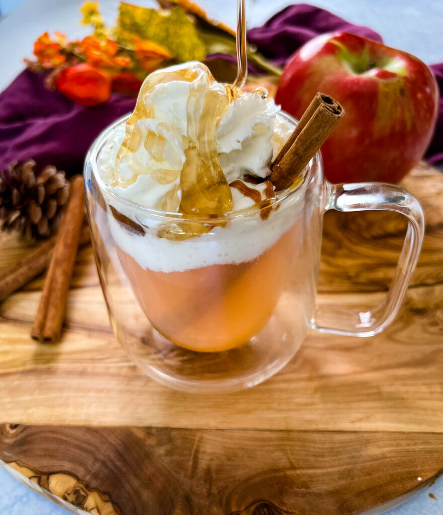 caramel apple spice cider Starbucks with whipped cream in a glass mug