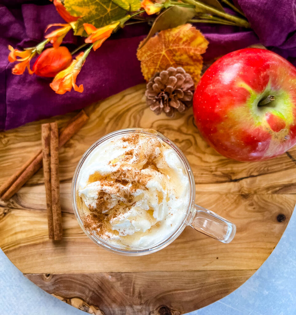 caramel apple spice cider Starbucks with whipped cream in a glass mug