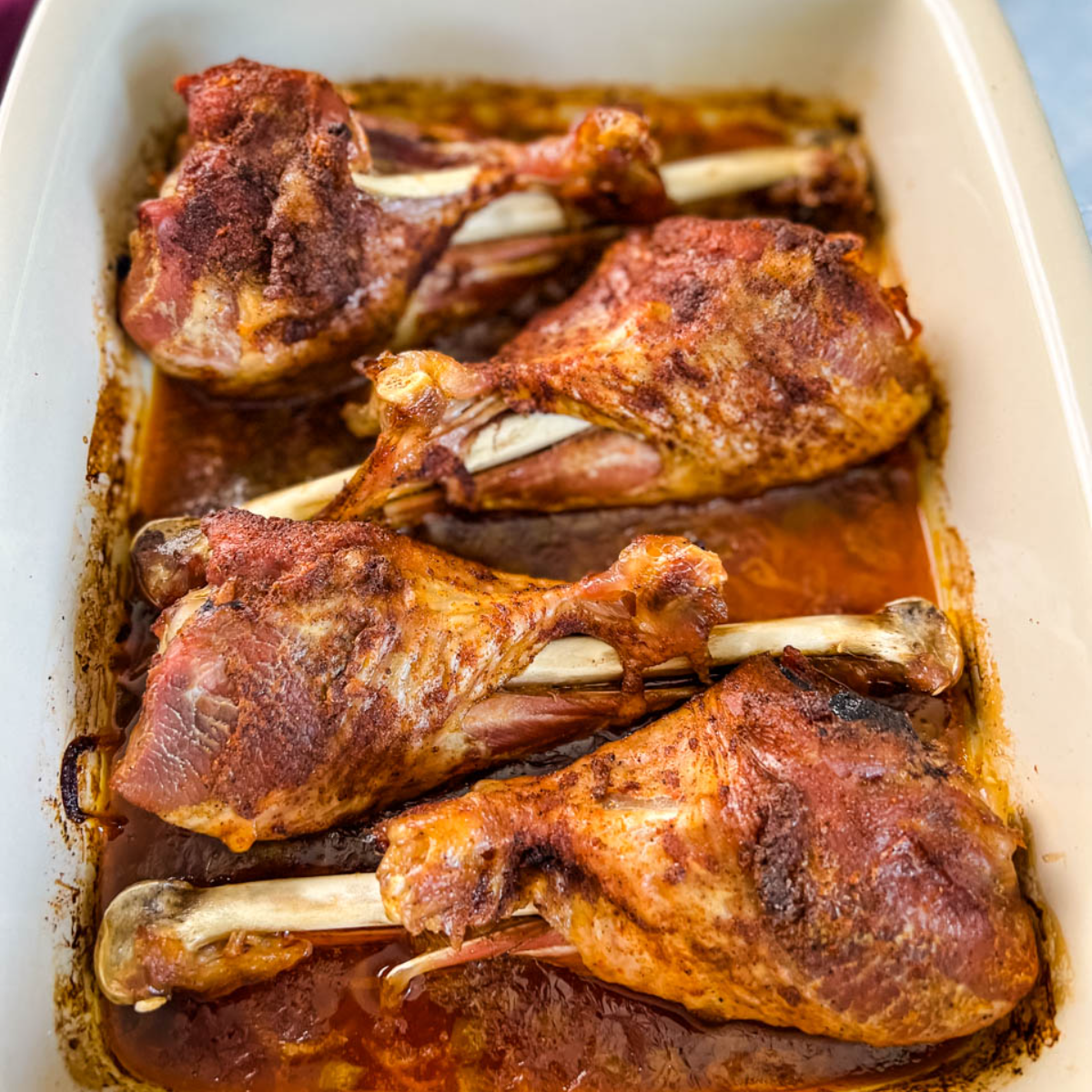 Chef taking off aluminum foil. Spicy marinated turkey legs cooked