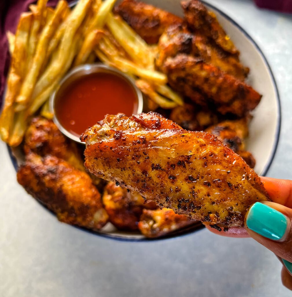 person holding Cajun chicken wing