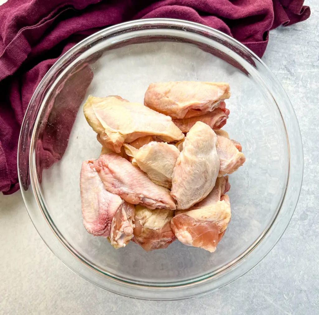 raw chicken wings in a glass bowl